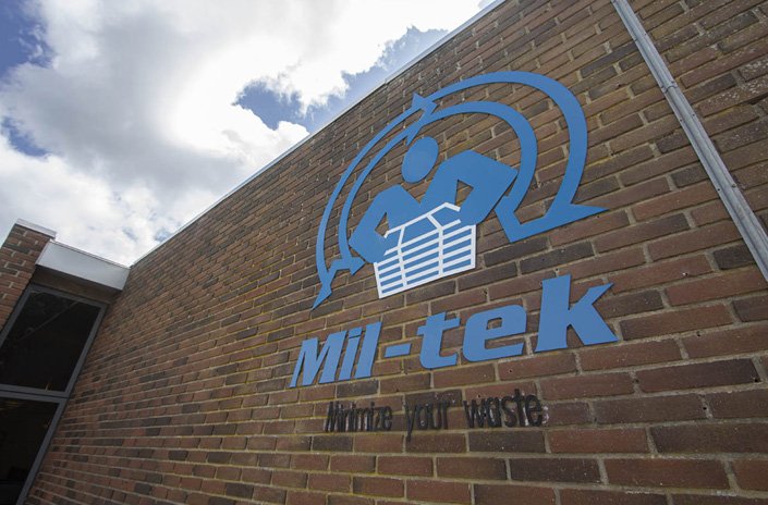 mil-tek-blåt-logo-på-ydermur-himmel-med-skyer