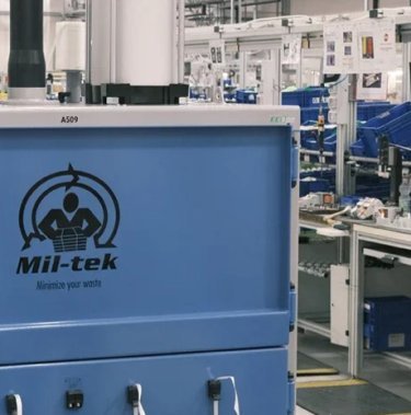 Nærbillede af blå ballepresser i produktionsmiljø