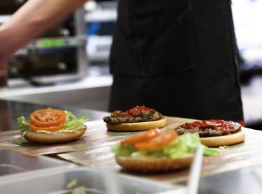Køkkenansat laver fastfood burgerer