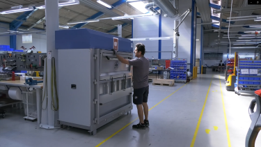 Mørkhåret mand bruger en stor ballepresser