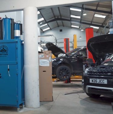 Blå Mil-tek ballepresser i bilværksted