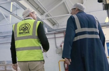 To mænd i sikkerhedstøj snakker